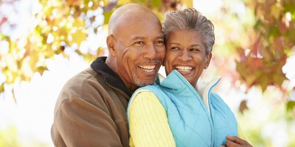 Elderly African American couple smiling and hugging