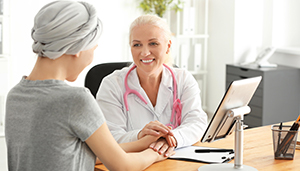 Caucasian female health care practitioner caring for Caucasian female cancer patient