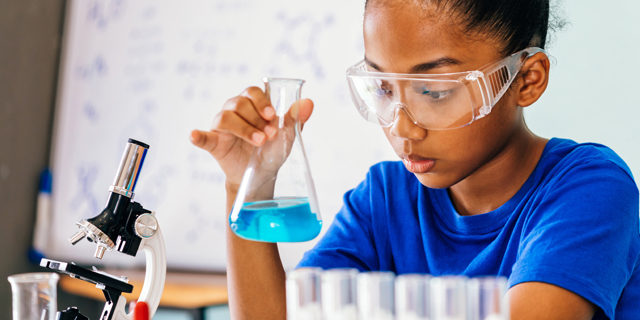 Young African American male student conducting science experiment