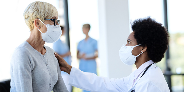 African American female health care practitioner caring for elderly Caucasian patient