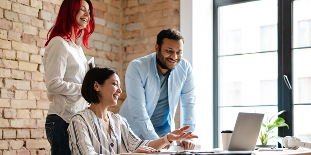 Two women and one man of differing ethnicities in business setting