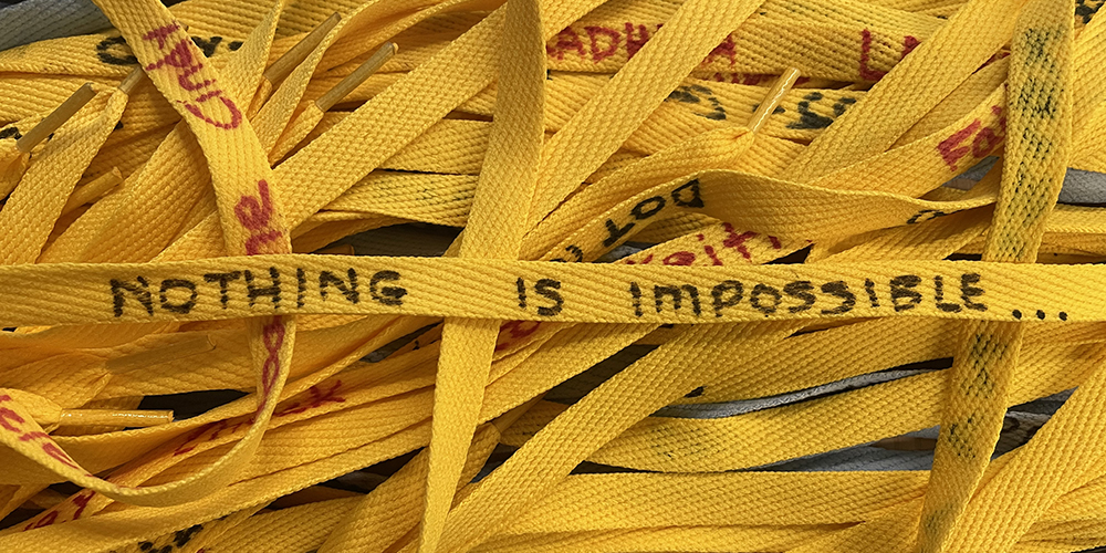 Several yellow shoelaces interlaced together with writing 