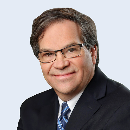 A headshot of Dale Shuster in suit