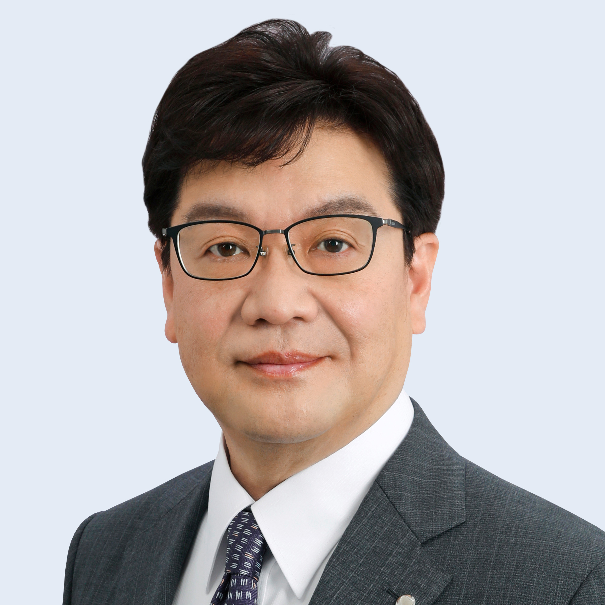 A headshot of Koji Sato in suit