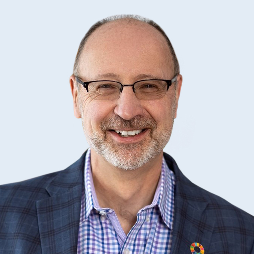 A headshot of Simon King in suit