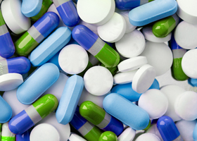 Collection of white tablets and blue, green and gray capsules