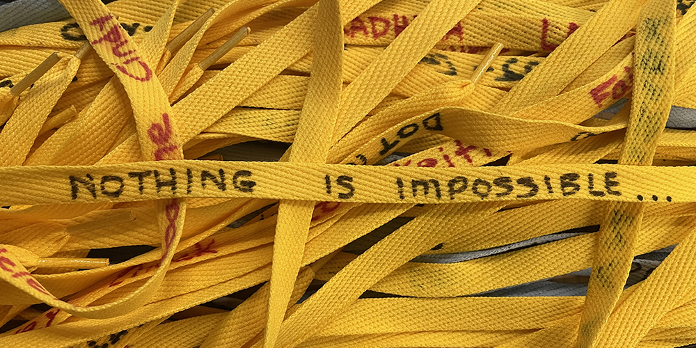 Several yellow shoelaces interlaced together with writing