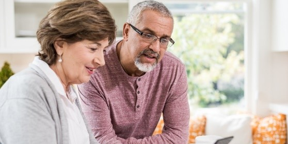 Middle Aged Male and Female Looking at a Laptop 